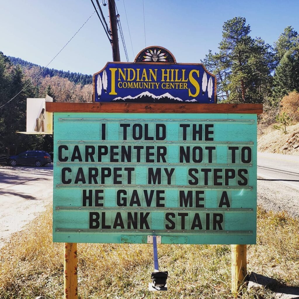Funny Indian Hills Community Center Road Sign Joke: I told the carpenter not to carpet my steps. He gave me a blank stair.