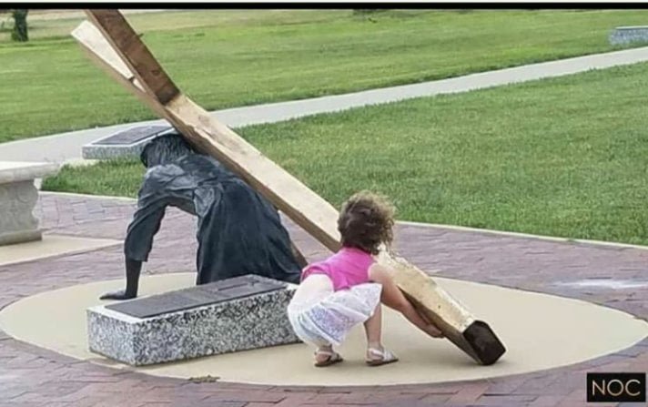 adorable innocent child helps jesus statue lift his cross