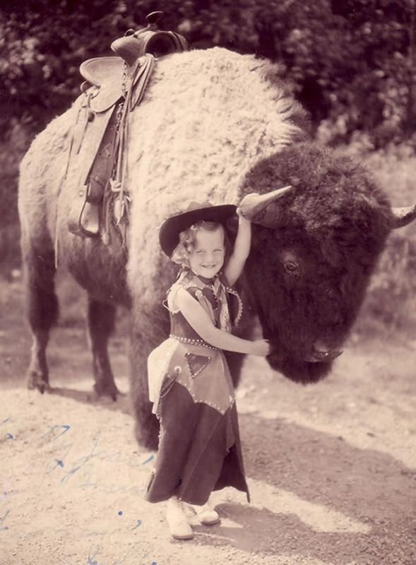 old black and white photo of child and buffalo